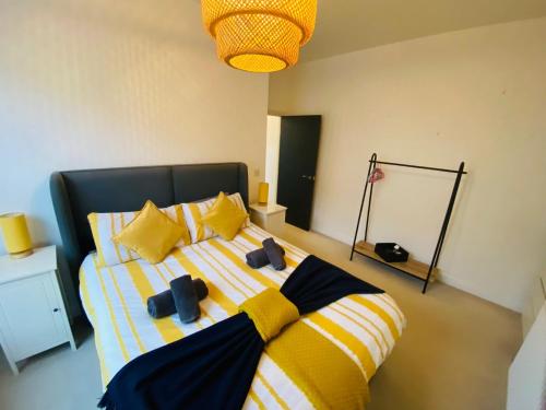 a bedroom with a bed with yellow and yellow pillows at Seascape Seaview Apartment hot tub hire subject to availability in Scarborough