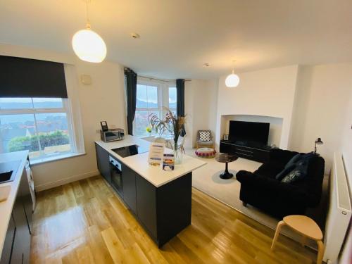 een woonkamer met een keuken en een bank bij Seascape Seaview Apartment hot tub hire subject to availability in Scarborough