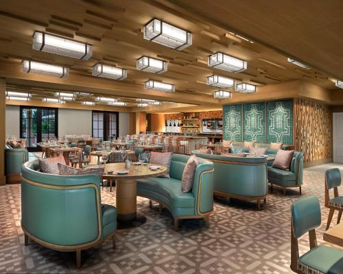 a restaurant with tables and chairs in a room at Palm House Hotel Palm Beach in Palm Beach