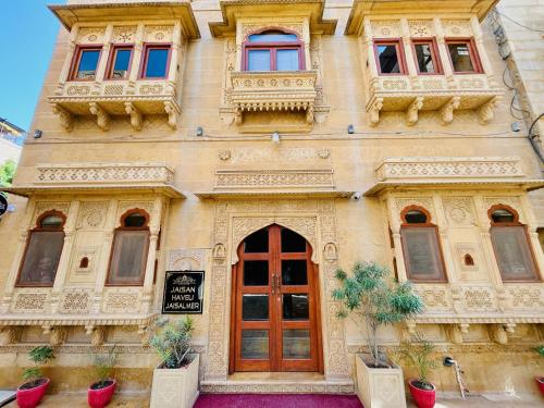 ジャイサルメールにあるHotel Jaisan Haveliの赤いドアと窓のある建物