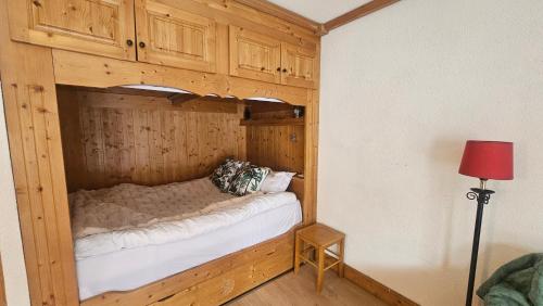 un lit dans une chambre avec un mur en bois dans l'établissement La famille au Ski, aux Houches