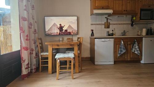 une cuisine avec une table et une cuisine avec un micro-ondes dans l'établissement La famille au Ski, aux Houches