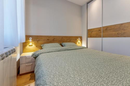 Un dormitorio con una cama grande y un espejo. en Srebrna Pahulja Zlatibor centar-Garazno mesto, en Zlatibor