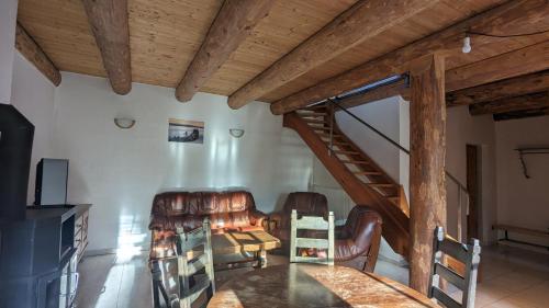 a living room with leather chairs and a wooden staircase at Abgeschiedene Ferienwohnung im Böhmerwald in Kašperské Hory