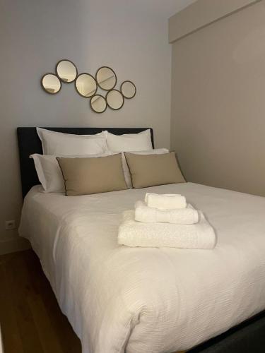 - un lit blanc avec 4 miroirs sur le mur dans l'établissement Appartement Swan House Paris Champs Elysée, à Paris