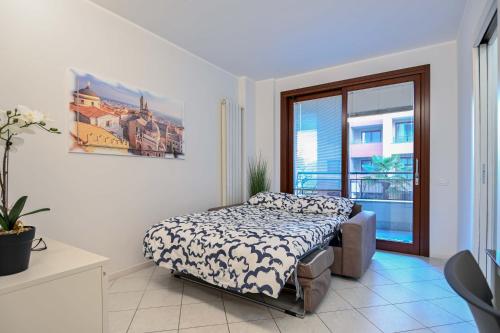 a bedroom with a bed and a large window at Bilocale Chic, 10 min Aeroporto Milano-Bergamo, BOX AUTO e ARIA CONDIZIONATA in Seriate