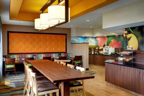 ポートヒューロンにあるFairfield Inn by Marriott Port Huronの大きな木製テーブルと椅子が備わるレストラン