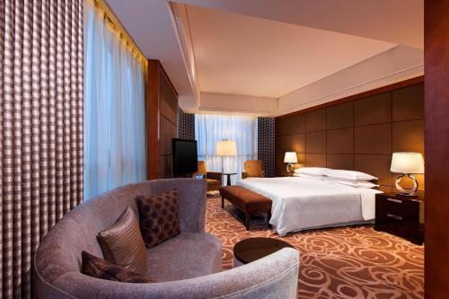 a hotel room with a bed and a chair at Four Points by Sheraton Suzhou in Suzhou