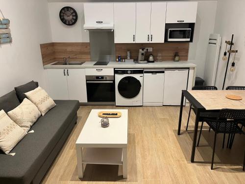 un salon avec un canapé et une cuisine dans l'établissement Loft du Pain avec SPA privatif, à Druye