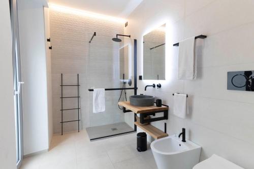 a white bathroom with a sink and a toilet at Sardinian Days - Suites & Rooms in Cagliari
