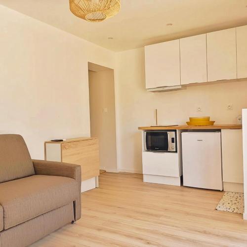 un salon avec un canapé et une cuisine dans l'établissement Appartement jacuzzi privé à 3 minutes cité médiévale, à Carcassonne