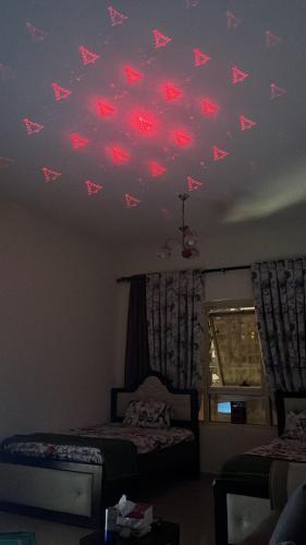 a bedroom with red butterflies on the ceiling at SHJ DXB Sunny Border Guesthouse in Dubai