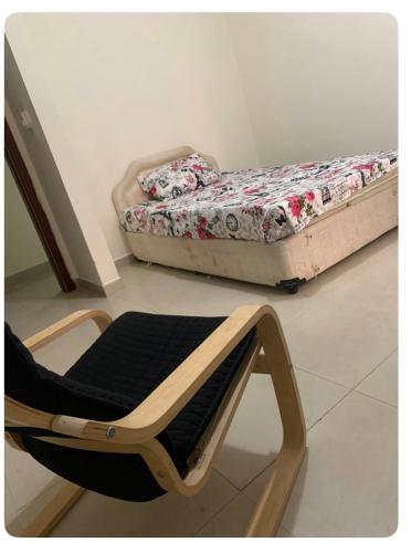 a chair sitting in a room with a bed at SHJ DXB Sunny Border Guesthouse in Dubai