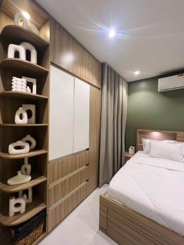 a bedroom with a bed and a book shelf at شقة أنوار مسقط in ‘Udhaybah