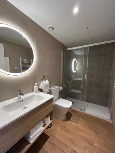 a bathroom with a sink and a toilet and a mirror at Apartamentos Turisticos Aeropuerto Barajas in Madrid
