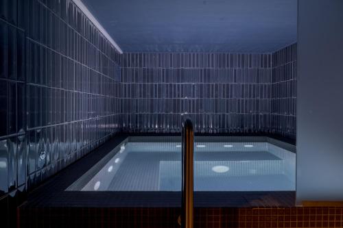 a swimming pool in a room with a tile wall at Villa Sardino in Settimo Vittone