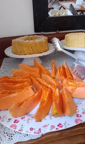 カラグアタトゥーバにあるPousada Sandramarのケーキと一緒にテーブルの上に置かれたスライスしたニンジンの皿