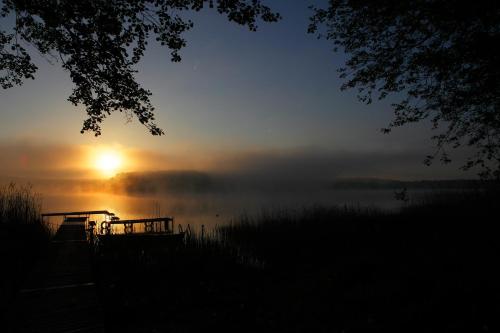 a misty sunrise on a lake with the sun setting at Ośrodek Wrzos in Boruja