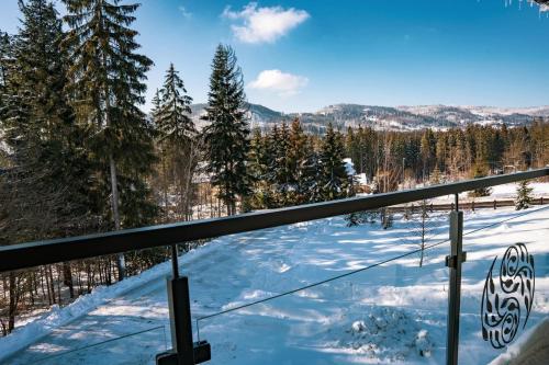 a view from a balcony in the snow at Srebrny Bucznik Wellness & Restaurant in Istebna