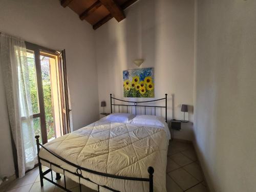 a bedroom with a bed and a painting on the wall at Villetta Pia in Contignano