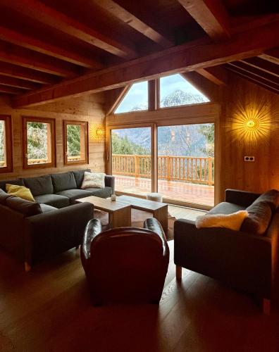 - un salon avec des canapés et une grande fenêtre dans l'établissement Chalet 14 personnes Alpe d Huez, à Oz