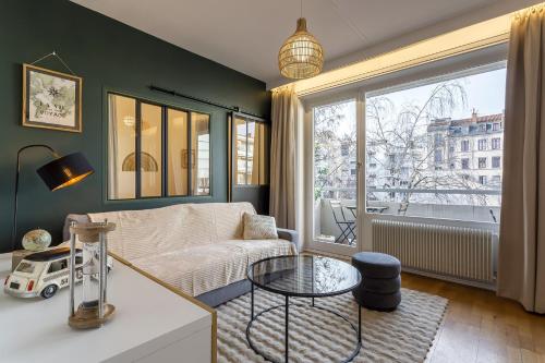 un salon avec un canapé et une fenêtre dans l'établissement SmartStay Capsule Cosy - Lyon Centre, à Lyon
