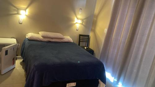 a small bed in a room with two pillows on it at Pousada Impera - Campos do Jordão in Campos do Jordão