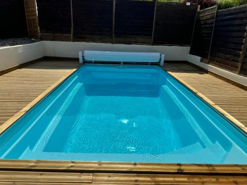 - une piscine avec un banc au-dessus dans l'établissement La ferme d'Hareauville - Heated swimming pool, à Criquetot-lʼEsneval