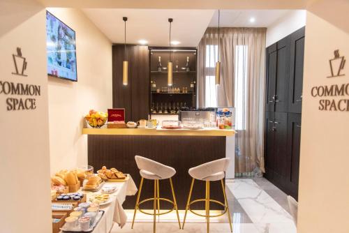 a breakfast bar with two stools and a table with food at Adelaide Suite Dreams in Rome