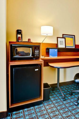 a room with a microwave and a desk and a table at Fairfield Inn and Suites by Marriott Durham Southpoint in Durham