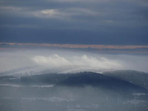 a view of a foggy valley with trees in the distance at Sněžník in Sněžnik