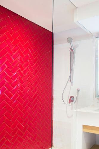 a red feature wall in a bathroom with a shower at Four Points by Sheraton Surabaya, Tunjungan Plaza in Surabaya