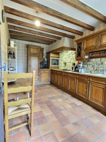 Il comprend une cuisine avec des placards en bois et du carrelage. dans l'établissement Le Reflet des Vignes by Miss K, à Péronne