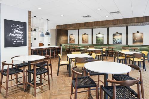 a restaurant with tables and chairs and a chalkboard at Fairfield Inn & Suites by Marriott Raleigh Wake Forest in Wake Forest