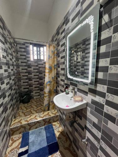 a bathroom with a sink and a mirror at Lovely 5-Bed House Getaway Duplex in Accra in Accra