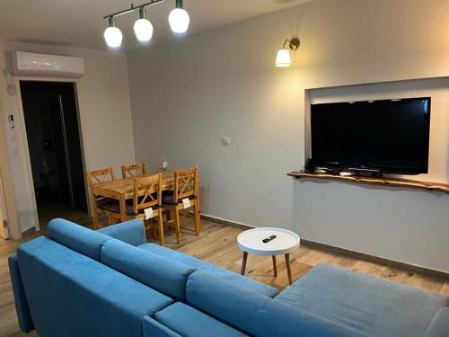 a living room with a blue couch and a table at נוף לעמק in Bruchim Qela' Alon