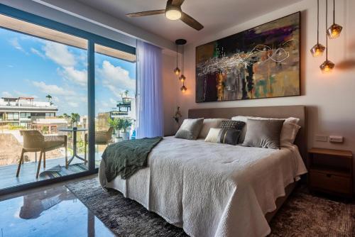 プラヤ・デル・カルメンにあるPlaya Azul Studio - Coco Beach Iのベッドと大きな窓のある寝室