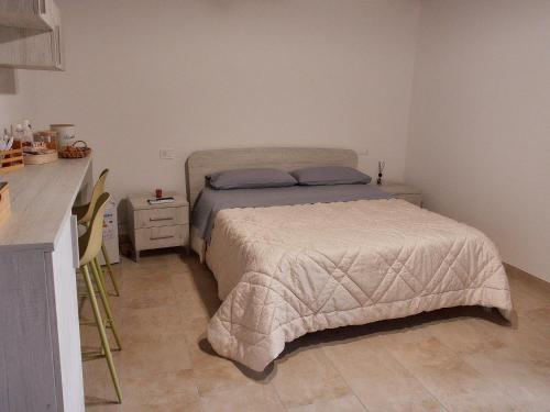 a small bedroom with a bed and a kitchen at Il Cortiletto del Borgo in Pietra Montecorvino