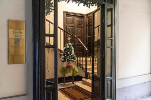 a glass door with a christmas tree on the stairs at Adelaide Suite Dreams in Rome