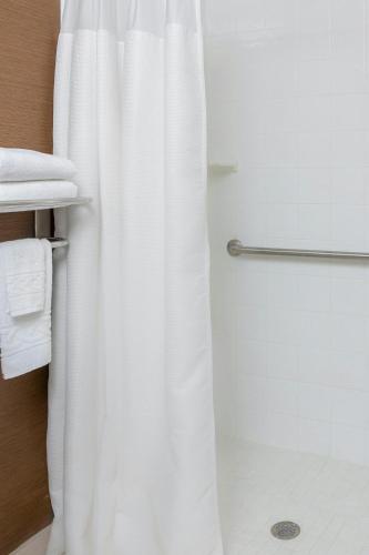 a bathroom with a shower with a white shower curtain at Fairfield Inn & Suites Lubbock in Lubbock