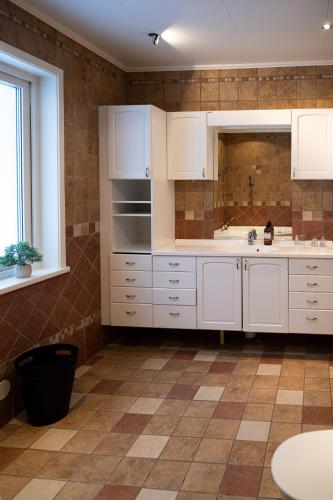 a kitchen with white cabinets and a sink at Villa Bessberget in Edsbyn