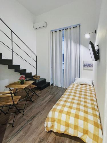 a bedroom with a bed and a table and stairs at I Quartieri Di Spaccanapoli B&B in Naples
