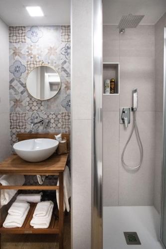 a bathroom with a sink and a shower with a mirror at I Quartieri Di Spaccanapoli B&B in Naples