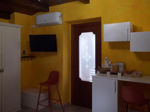 a kitchen with yellow walls and a window and a counter at Il Cortiletto del Borgo in Pietra Montecorvino