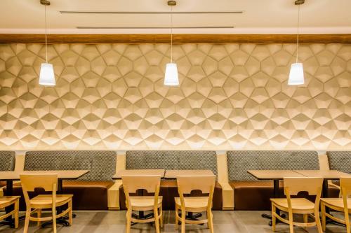 a restaurant with tables and chairs and a wall at Fairfield Inn & Suites Queretaro Juriquilla in Querétaro