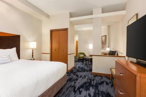 a hotel room with a bed and a flat screen tv at Fairfield Inn & Suites Jacksonville West/Chaffee Point in Jacksonville