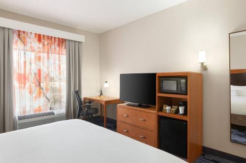a hotel room with a bed and a television at Fairfield Inn & Suites Jacksonville West/Chaffee Point in Jacksonville