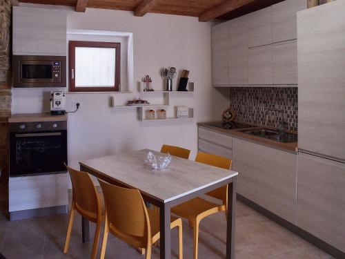 a kitchen with a table and chairs in a room at Il Cortiletto del Borgo in Pietra Montecorvino