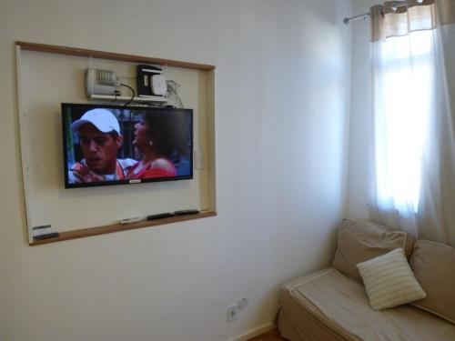 uma televisão pendurada numa parede numa sala de estar em Copacabana wonderful apartment no Rio de Janeiro