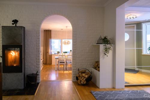 an open living room with a fireplace and a dining room at Villa Bessberget in Edsbyn